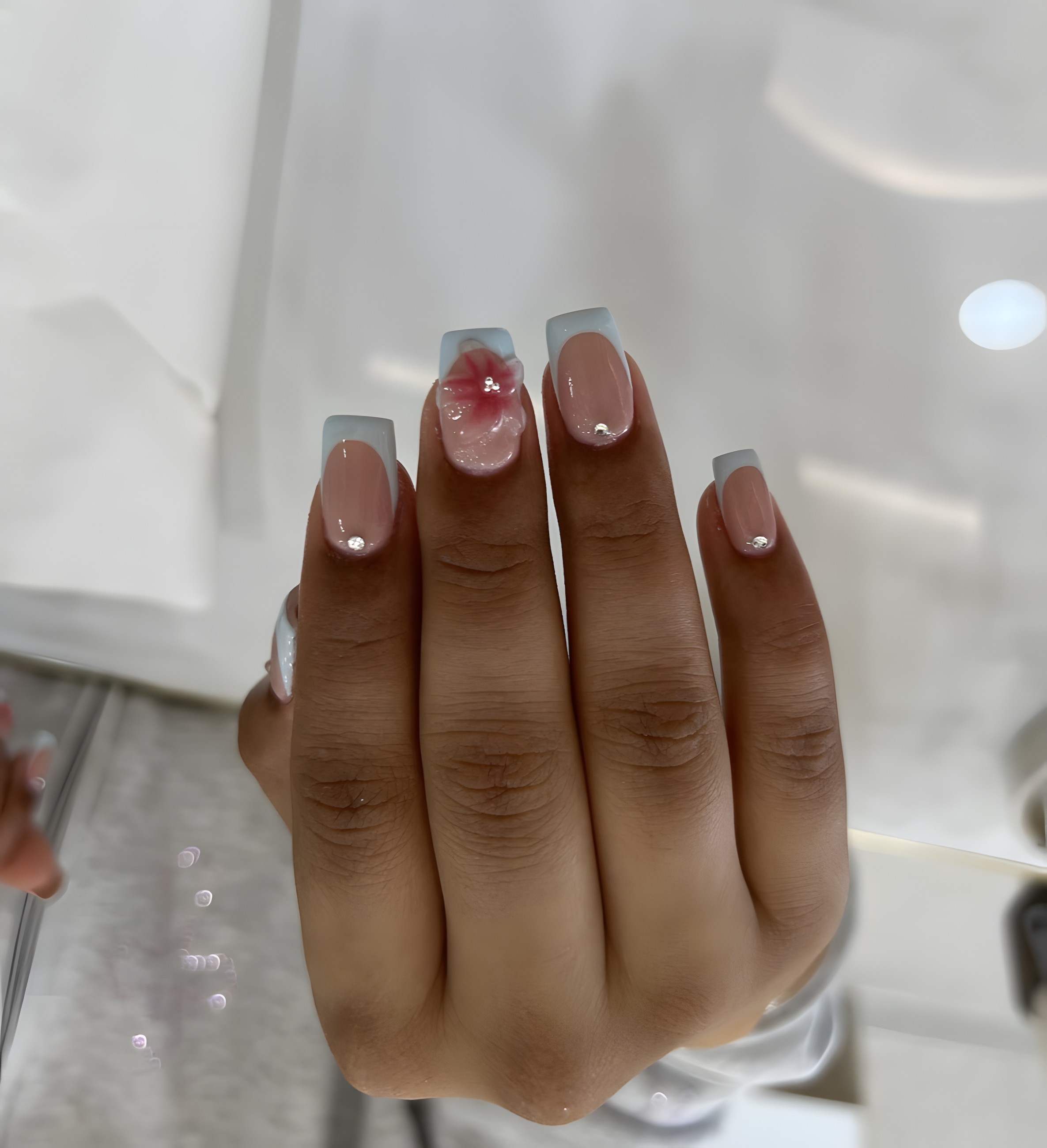 Soft blue French nails with a painted flower