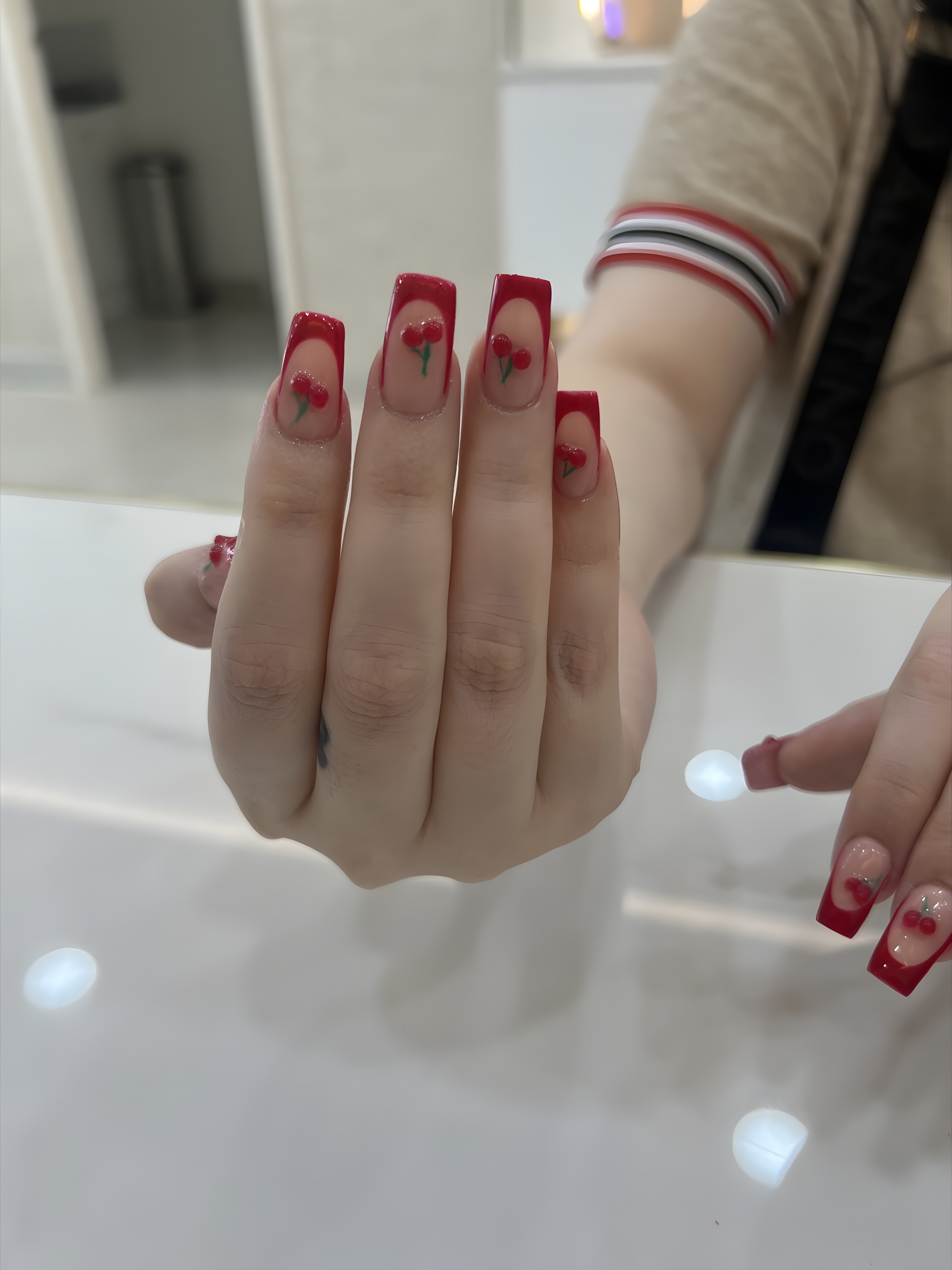 Red gel nails with hand-painted cherry nail art