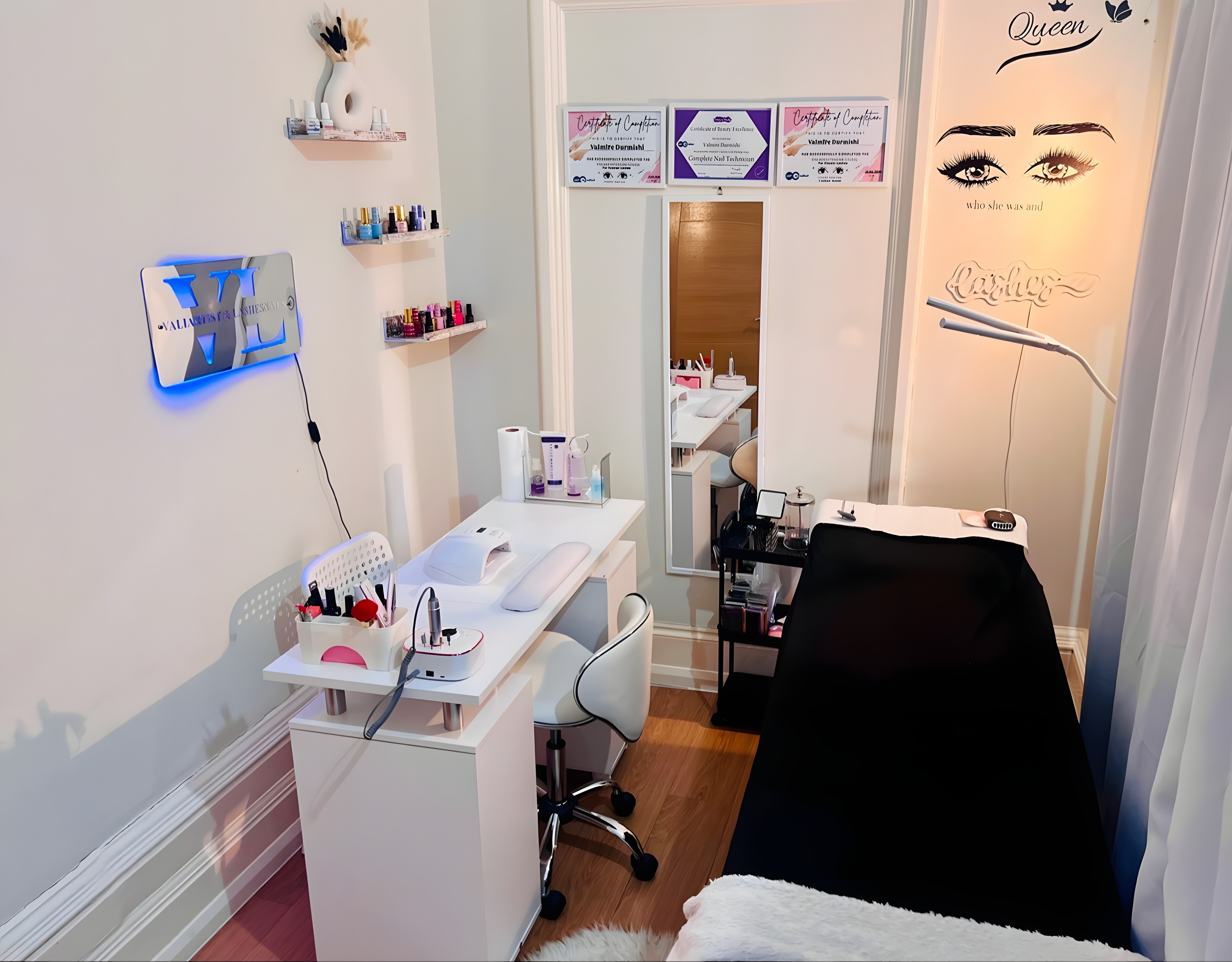 Inside Lashes&Nails by Vali, the manicure station with the illuminated VL logo and eyelash wall art
